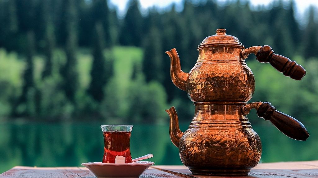 Copper çaydanlık with Turkish tea by lakeside.