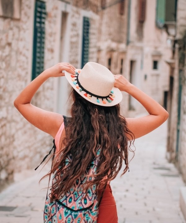 Girl walking through charming Turkish streets, captured from behind in a moment of quiet wonder