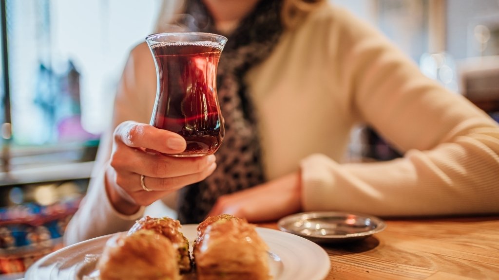 I am enjoying traditional Turkish tea with baklava at a cozy Istanbul café – highlighting the cultural ritual and taste of authentic Turkish black tea