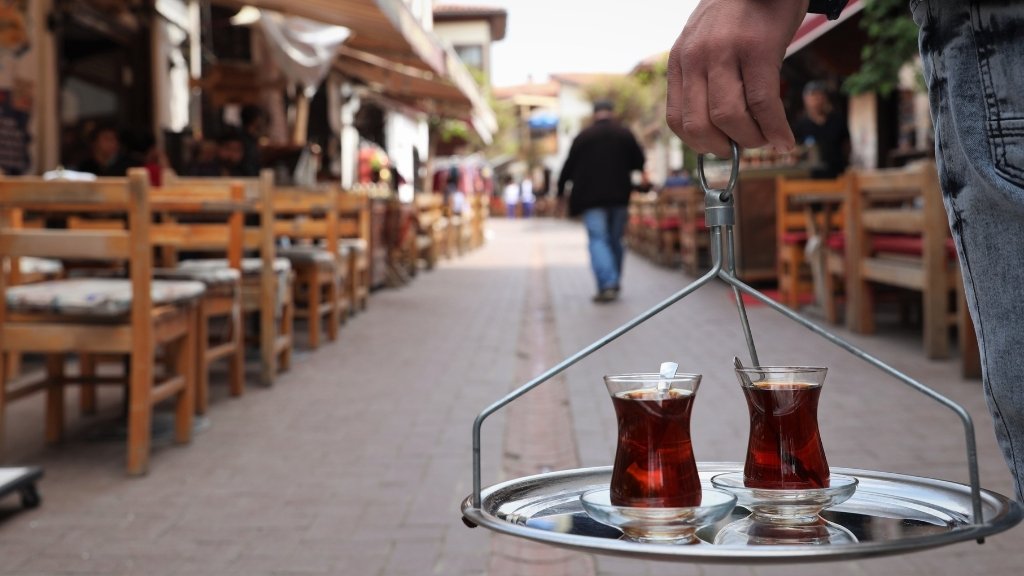 Traditional serving of Turkish Black Tea in tulip glasses on a street café tray.