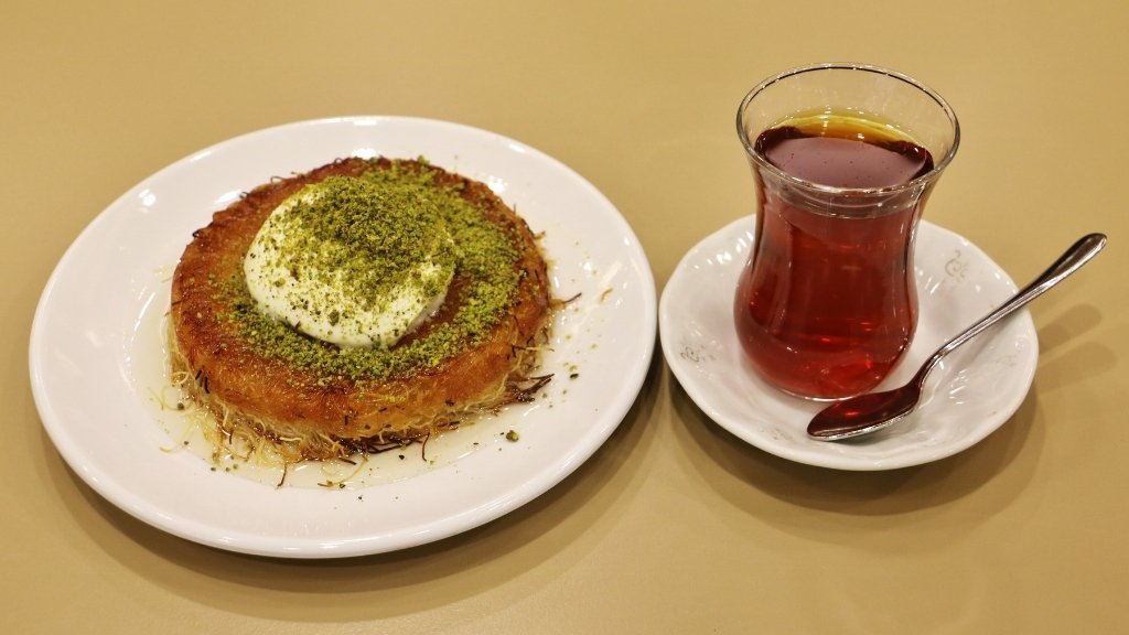 Turkish Black Tea served with traditional künefe dessert topped with pistachios.