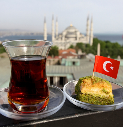 Turkish tea and baklava with Turkish flag and mosque view in Istanbul