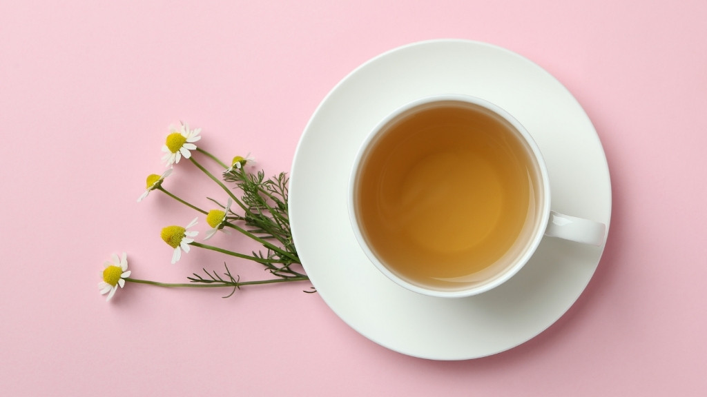 Chamomile tea in a delicate cup with daisy‑like blossoms, warm golden brew for relaxation.