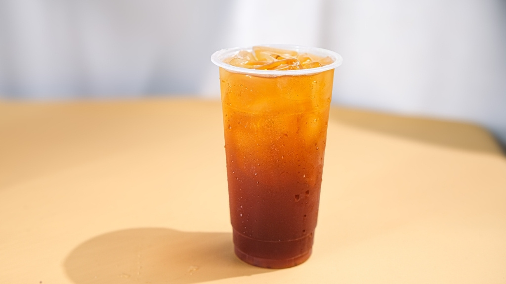 Plain Turkish iced tea served in a clear plastic cup with ice - a simple and bold example from the traditional Turkish iced tea recipe guide.