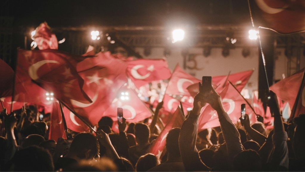 People celebrating with Turkish flags at a national event, reflecting unity, patriotism, and Turkish traditions and customs.