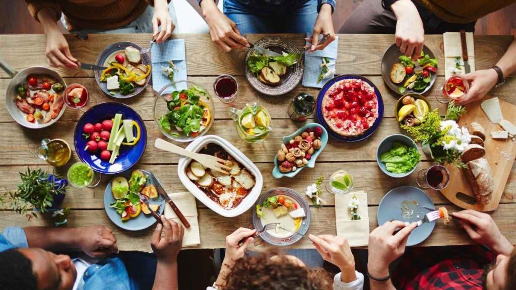 Top view of a shared meal with fresh salads, bread, desserts, and drinks, symbolizing the communal spirit and traditions of Turkish dining etiquette.